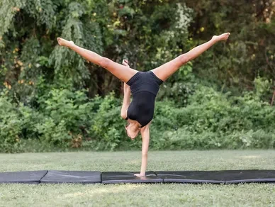 Acrobatics dancer performing handstand outdoors